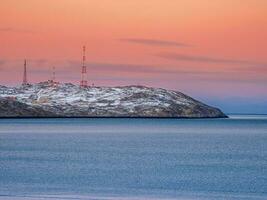 cell torn i de snötäckt kullar i tundra. skön solnedgång kuperad landskap av de arktiska. foto