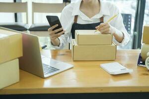 kvinna uppkopplad företag ägare kontroll beställa använder sig av mobiltelefon. foto
