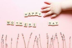 mödrar dag kort. gåva för mamma från bebis. inskrift från brev Lycklig mödrar dag. mödrar dag layout på rosa bakgrund foto