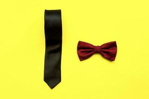 platt lägga rosett slips och slips på en gul bakgrund. Lycklig fäder dag. manlig attribut foto