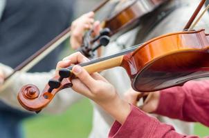 händerna på en gatumusikantflicka med fiol foto