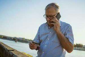 senior man på en telefon ring upp foto