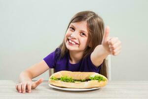 en flicka äter en smörgås foto