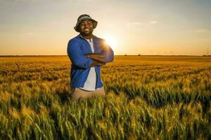 afro jordbrukare stående i en vete fält foto