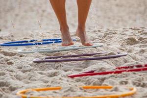 fötter gör övningar på en funktionell träningsstege på strandsanden. foto