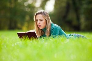 en kvinna utgifterna tid utomhus och läsning en bok foto