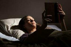 en kvinna läsning på en läsplatta foto