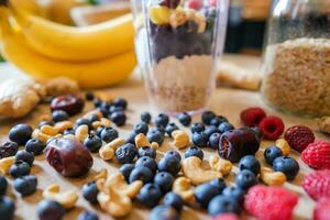 friska protein skaka på tabell med frukt och grönsaker Ingredienser runt om foto