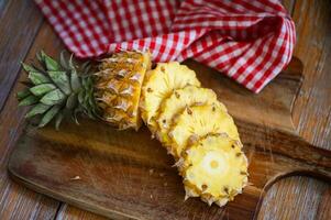 ananas skiva trä- skärande styrelse för mat frukt mogen ananas på bakgrund, färsk ananas tropisk frukt sommar foto