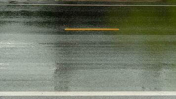 våt av tung regn på asfalt väg. för transport bakgrund. stänga upp på gul linje på de Centrum av väg. foto