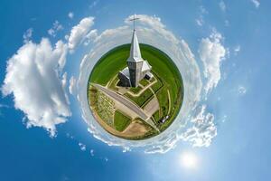 liten planet omvandling av sfärisk panorama 360 grader utsikt kyrka i Centrum av klot i blå himmel. sfärisk abstrakt antenn se med krökning av Plats. foto