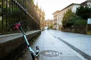 elektrisk skoter cykel mager på betong vägg bredvid gata i Europa. eco transport på gammal stad väg. urban livsstil. framtida transport. hållbar livsstil. historisk byggnad arkitektur. foto