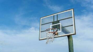 låg vinkel se av basketboll ringa på himmel bakgrund. utomhus- basketboll ring. foto