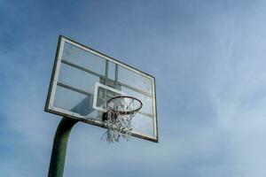 låg vinkel se av basketboll ringa på himmel bakgrund. utomhus- basketboll ring. foto