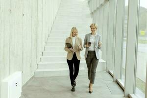 företag kvinnor gående i de kontor korridor foto