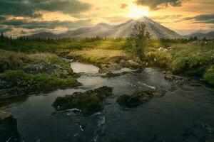 hisnande solnedgång landskap landskap med flod ström, skog och bergen i de bakgrund på connemara nationell parkera i grevskap galway, irland foto