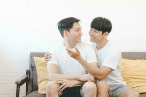 Lycklig asiatisk Gay par kram tillsammans på soffa. asiatisk HBTQ par fattande tillsammans på Hem. mångfald av HBTQ relationer. en Gay par begrepp. HBTQ mång relation. foto