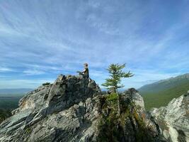 buryatia, Ryssland, 2022 - en ung kvinna mediterar på en bergstopp i de sayan berg. foto