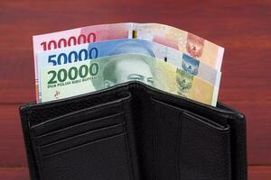 indonesiska pengar - rupiah i de svart plånbok foto