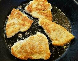 panerad wiener schnitzel med sida maträtter foto