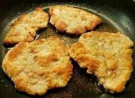 panerad wiener schnitzel med sida maträtter foto