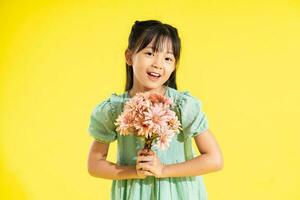 Lycklig leende asiatisk flicka på gul bakgrund foto