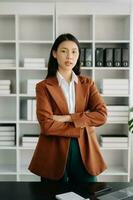 ung attraktiv asiatisk kvinna kontor arbetstagare företag kostymer leende på kamera i modern kontor foto