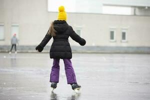 en flicka skridskor på is i vinter. foto