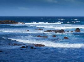 vågor och stenig strand vid Puerto de la Cruz tenerife kanarieöarna foto