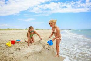 barn spela med sand på strand. foto