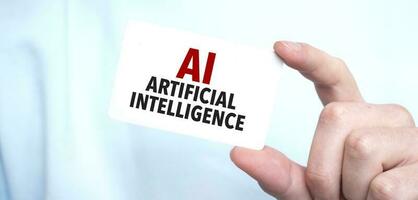 man i blå tröja innehav en kort med text ai - artificiell intelligens, företag begrepp foto