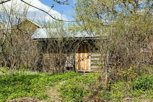 trä- ladugård med stängd dörr på gård i by foto