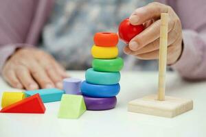 asiatisk äldre kvinna spelar pussel spel till öva hjärna Träning för demens förebyggande, alzheimers sjukdom. foto