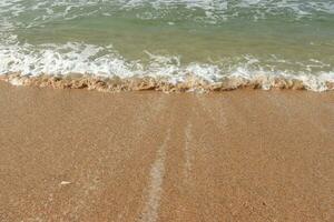 skön vågor på de sand strand bakgrund. foto