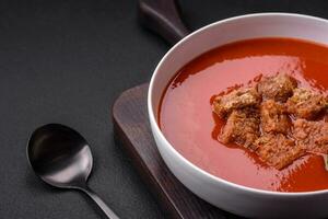utsökt färsk gazpacho med ströbröd, salt och kryddor i en keramisk tallrik foto