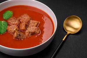 utsökt färsk gazpacho med ströbröd, salt och kryddor i en keramisk tallrik foto