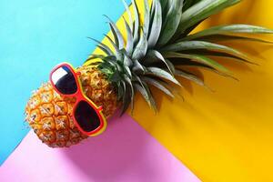 ananas bär solglasögon på en gul bakgrund foto