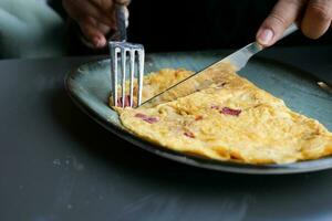 äter enkel ägg omelett på tabell foto