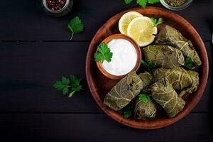 dolma. fylld druva löv med ris och kött på mörk tabell. mitten östra kök. topp se, över huvudet, kopia Plats foto