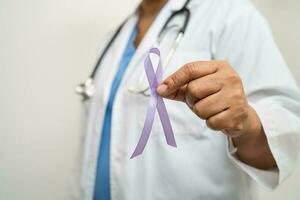 asiatisk kvinna läkare med lila band, tecken av alzheimers sjukdom dag, pankreas- cancer, epilepsi, lupus. foto