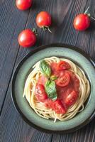 pasta med tomat sås och färsk basilika på de tallrik foto