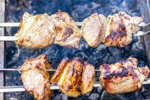 matlagning en utegrill på de brand. traditionell caucasian kebab på en grillspett, matlagning kött på spett. foto