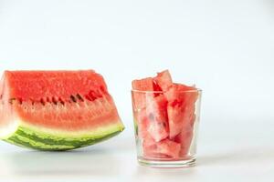 röd mogen vattenmelon, skivad på en vit bakgrund. vattenmelon skivor i en glas. foto