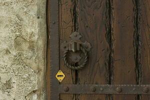 arkitektonisk element av de vägg. bakgrund närbild av en grunge metall hantera på ett gammal järn dörr. ett gammal dörr med lås och rostig handtag. foto