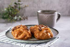 korg- bullar med kanel, nötter och lönn sirap och en kopp av kaffe för svenska fika tid foto