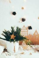 organisation av en festlig jul tabell. gran bukett i en vas dekorerad med trä- ornament på de jul tabell. miljövänlig och hemlagad livsstil. vertikal se foto