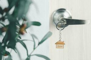 stänga upp nyckel på de dörr med morgon- ljus, personlig lån begrepp. hus modell och nyckel i hus dörr. verklig egendom ombud erbjudande hus, fast egendom försäkring och säkerhet, prisvärd hus begrepp. foto