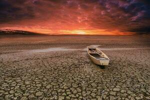 trä- roddbåt på knäckt jord i klimat torka foto