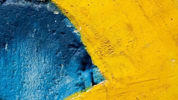 gammal blå och gul cementvägg foto