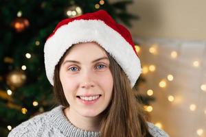 porträtt av en ung kvinna i en grå tröja och jultomtenhatt foto